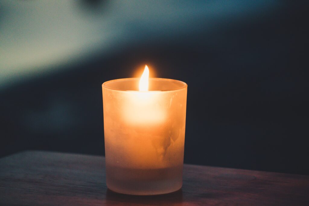 Photo of a candle in a darkened room. Decoration.